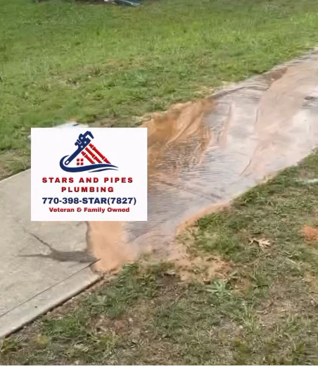 Main water service line leak flooding across the sidewalk of a Snellville, GA front yard before replacement by Stars and Pipes Plumbing Atlanta