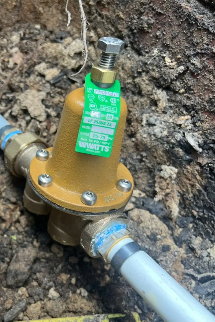 The new pressure reducing valve installed on the supply line.